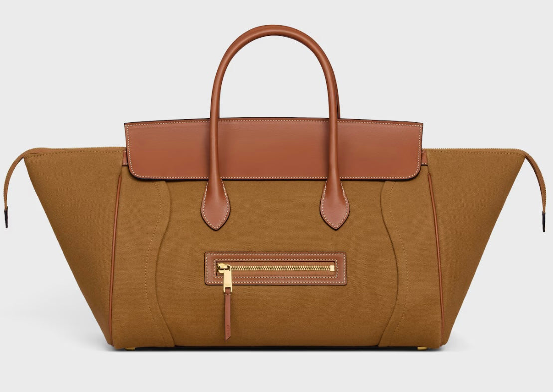 Celine Phantom Luggage bag in tan calfskin with wide side wings, brown rounded handles and trim, curved front detailing and a gold-tone front zip against a pale background.