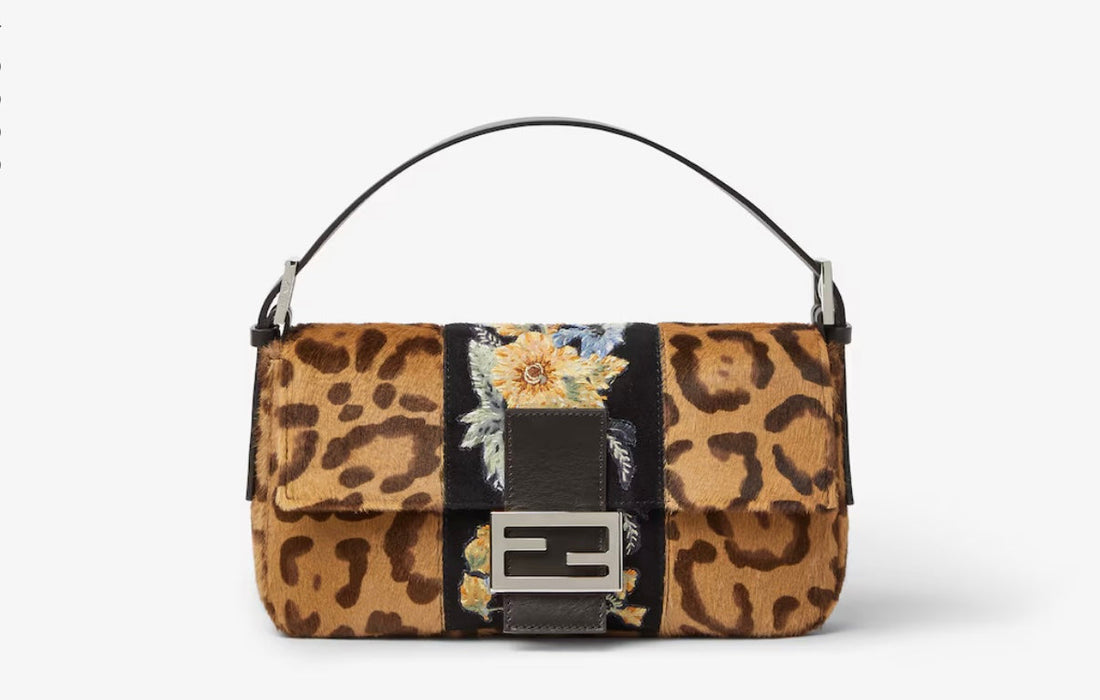 Fendi Baguette bag with a brown leopard pattern, floral detail on a black central panel, a short black strap and silver-tone FF fastening against a pale background.